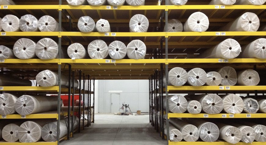Warehouse racks of mill-direct flooring and turf roll goods