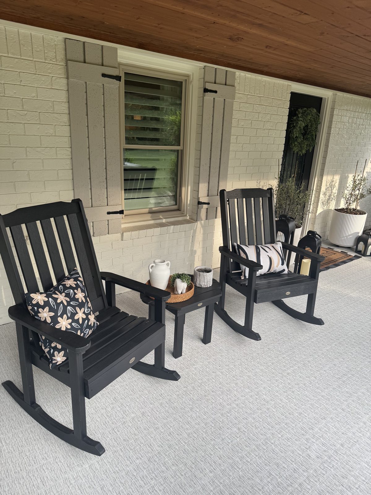 Woven vinyl porch flooring with rocking chairs and a brick facade
